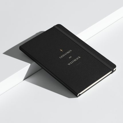 Schwarzes Hardcover-Notizbuch „Gedanken mit Weitblick“ mit heller Typografie, schräg aufgestellt.