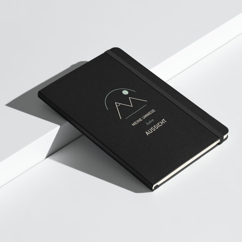 Schwarzes Hardcover-Notizbuch mit Berglinien, Sonne und „Meine Umwege haben Aussicht“