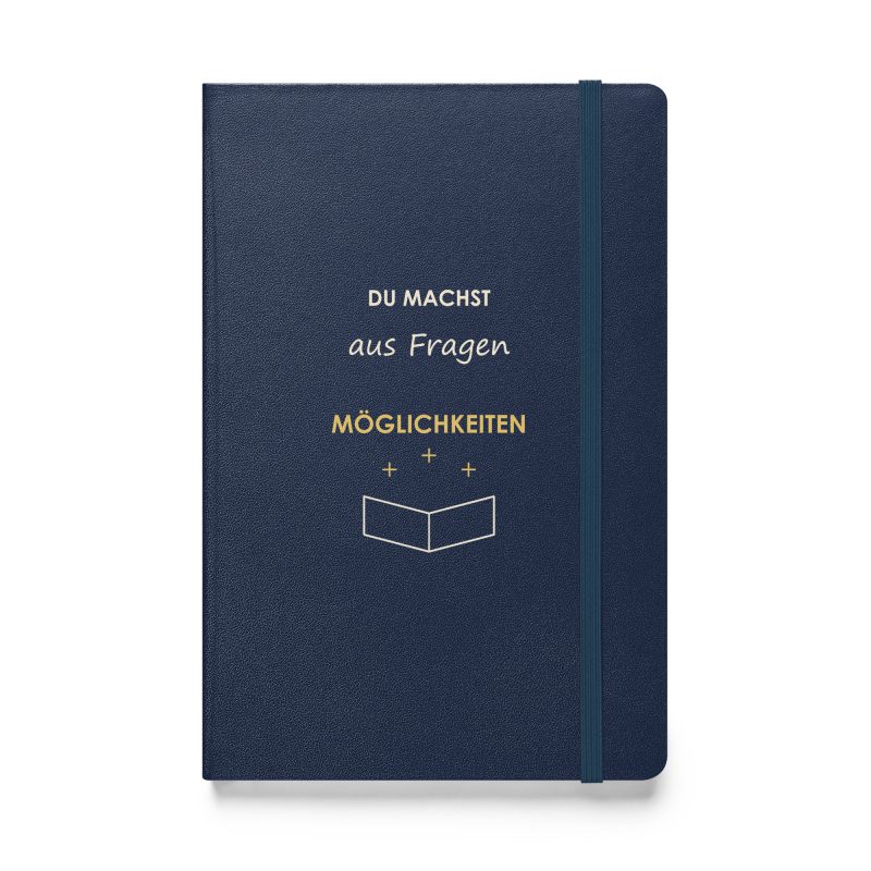 Marineblaues Hardcover-Notizbuch „Du machst aus Fragen Möglichkeiten“ mit offenem Buch und kleinen Strahlen