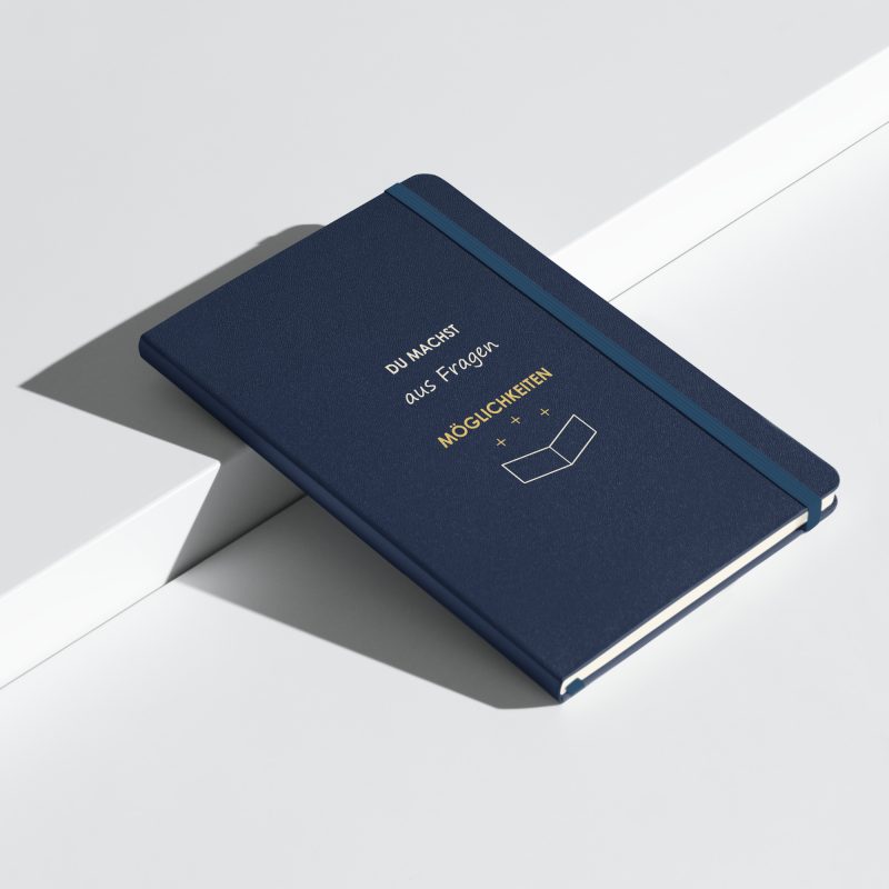 Marineblaues Hardcover-Notizbuch „Du machst aus Fragen Möglichkeiten“, schräge Ansicht