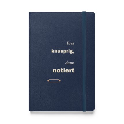 Notizbuch in Navy mit cremefarbener Schrift „Erst knusprig, dann notiert“ und kupferfarbenem Nudelholz – Vorderansicht