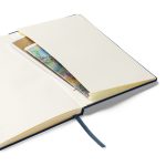 Geöffnetes marineblaues Hardcover-Notizbuch mit cremefarbenen linierten Seiten und Innentasche