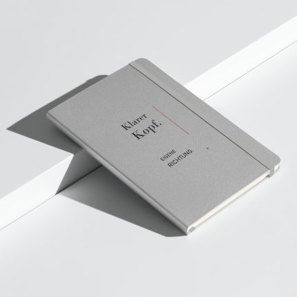 Silbernes Hardcover-Notizbuch mit großer dunkler Typografie „Klarer Kopf. Eigene Richtung.“
