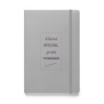 Silbernes Hardcover-Notizbuch „Kleine Stiche, große Vorhaben“ mit dunkler Pflaumenschrift und Stichrahmen
