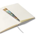Geöffnetes silbernes Hardcover-Notizbuch mit cremefarbenen linierten Seiten, Lesebändchen und Innentasche