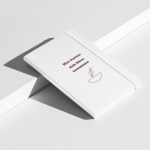 Weißes Hardcover-Notizbuch mit brauner Rundschrift und Backmotiv, schräge Ansicht