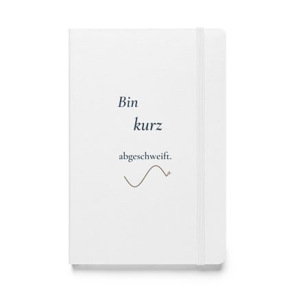 Weißes Notizbuch mit dunkelblauer Schrift „Bin kurz abgeschweift.“ und geschwungener Linie, Vorderansicht.